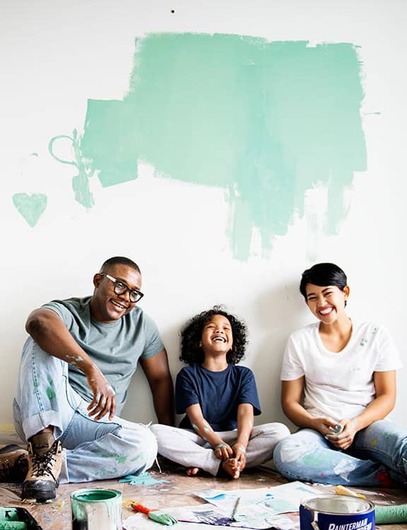 family painting walls and laughing together