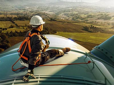 environmental engineer sitting on top of wind turbine