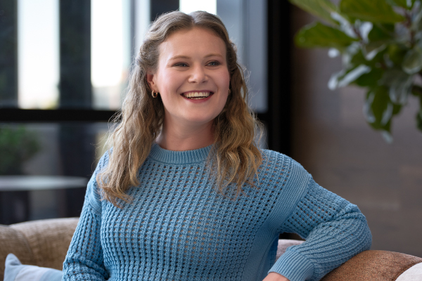 Naomi Parker sitting on a couch smiling