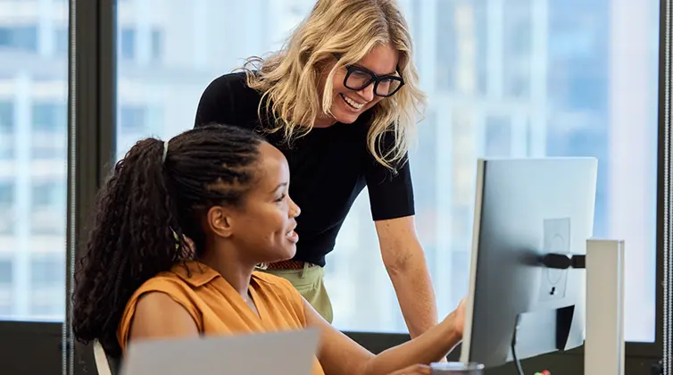 Two women looking at a computer monitor