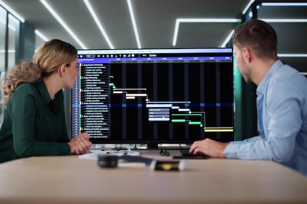 IT project managers looking at data on screen