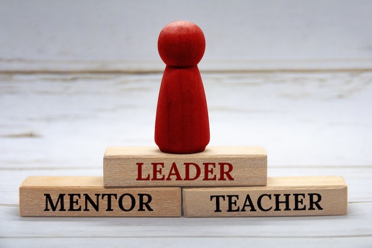 wooden blocks reading leader, mentor, teacher